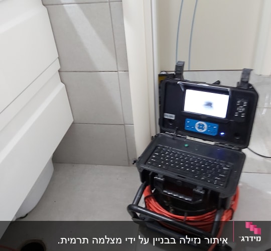 מכשיר איתור נזילות עם מסך ומצלמה בחדר אמבטיה